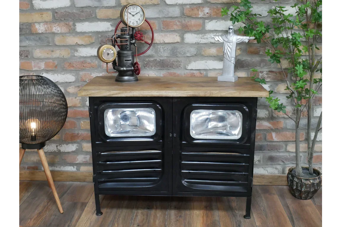 Industrial sideboard with black metal doors, wood top, and headlight detail against brick wall