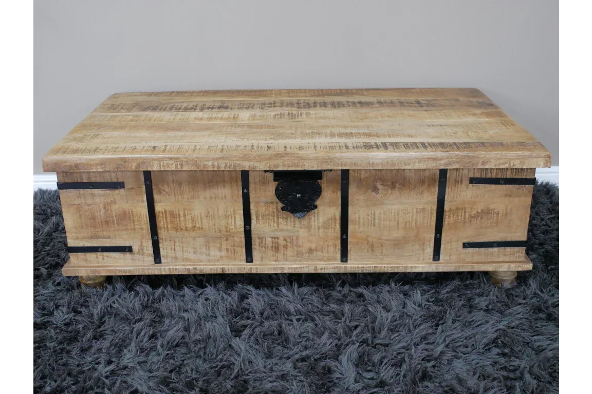 Solid wood storage trunk with black metal accents on a grey textured rug