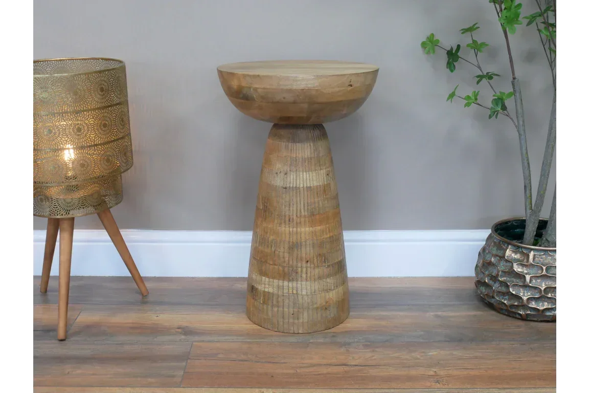 Solid wood side table with round top and tapered base on hardwood floor