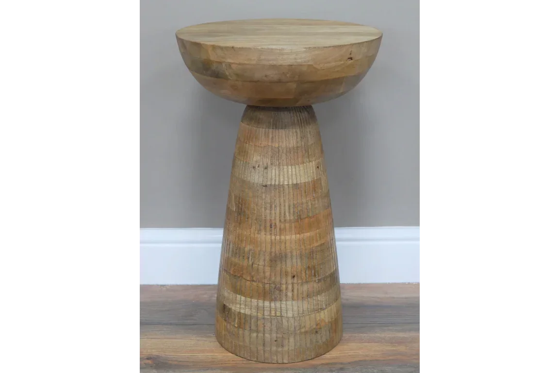 Round wooden side table with natural finish and tapered base on hardwood floor