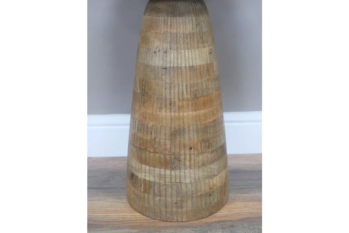 Tapered wooden table base with natural wood grain on laminate floor