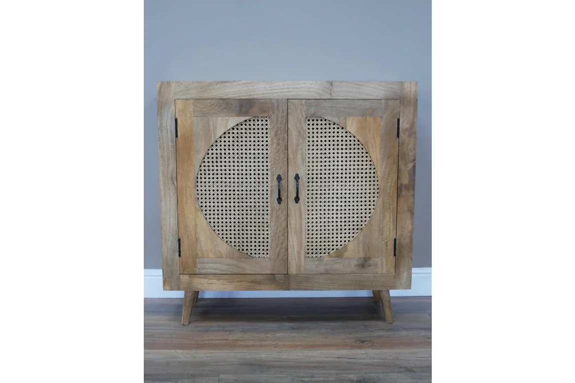 Wooden sideboard with cane panel doors and metal handles on wooden floor