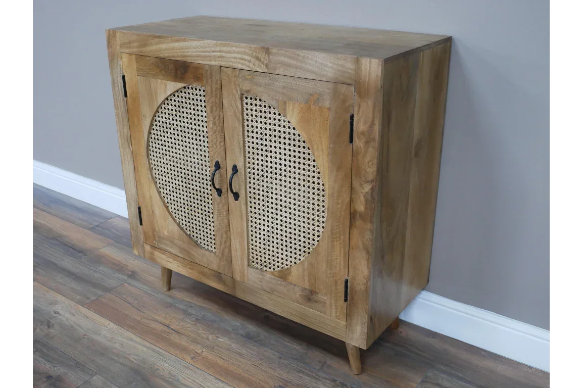 Wooden sideboard cabinet with cane webbing doors and black handles against a grey wall