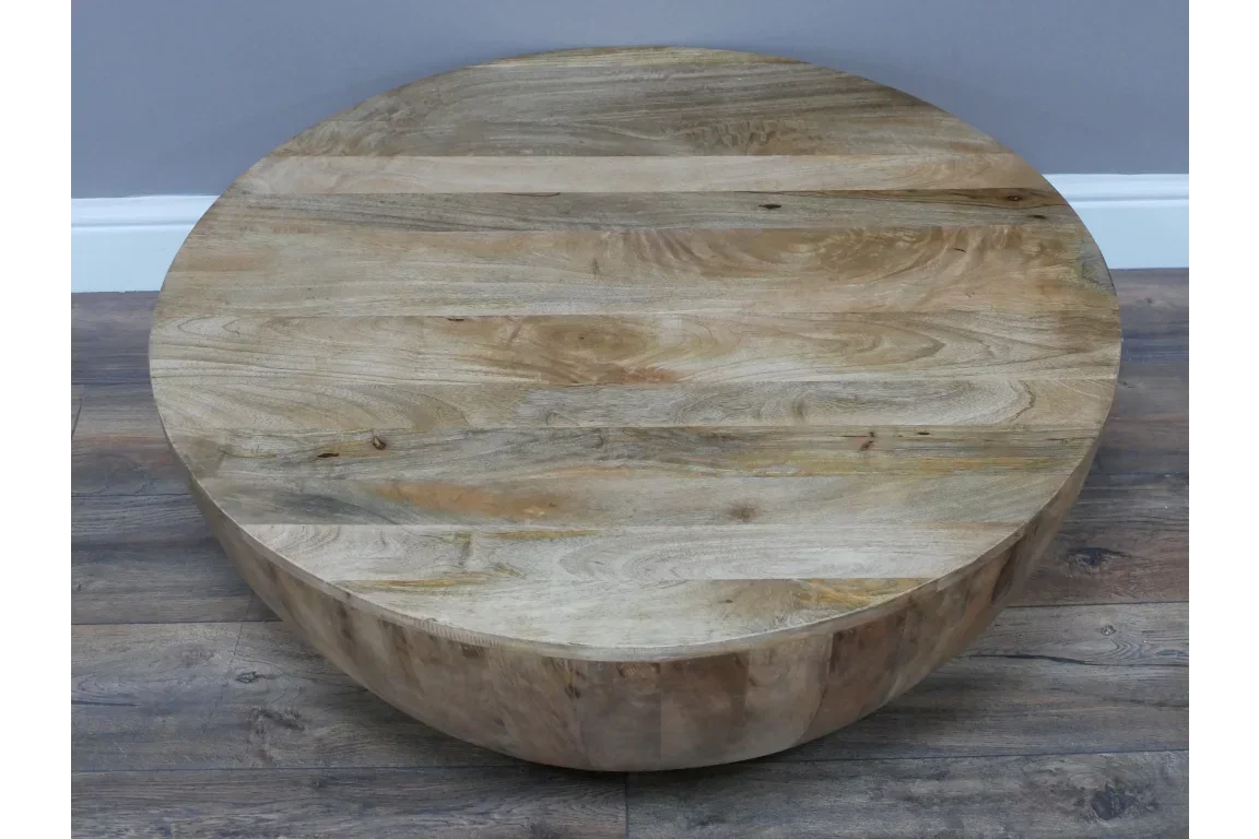 Round solid wood coffee table with natural grain on wood floor
