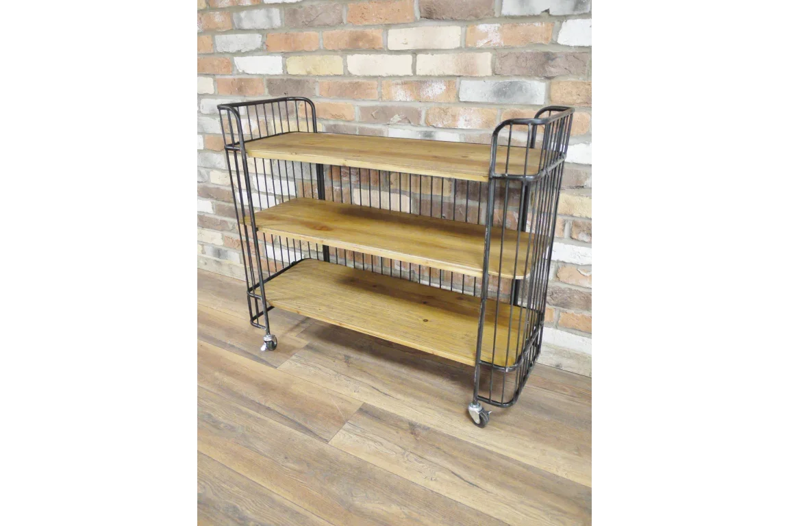 Industrial shelving unit with three wooden shelves and black metal frame on casters