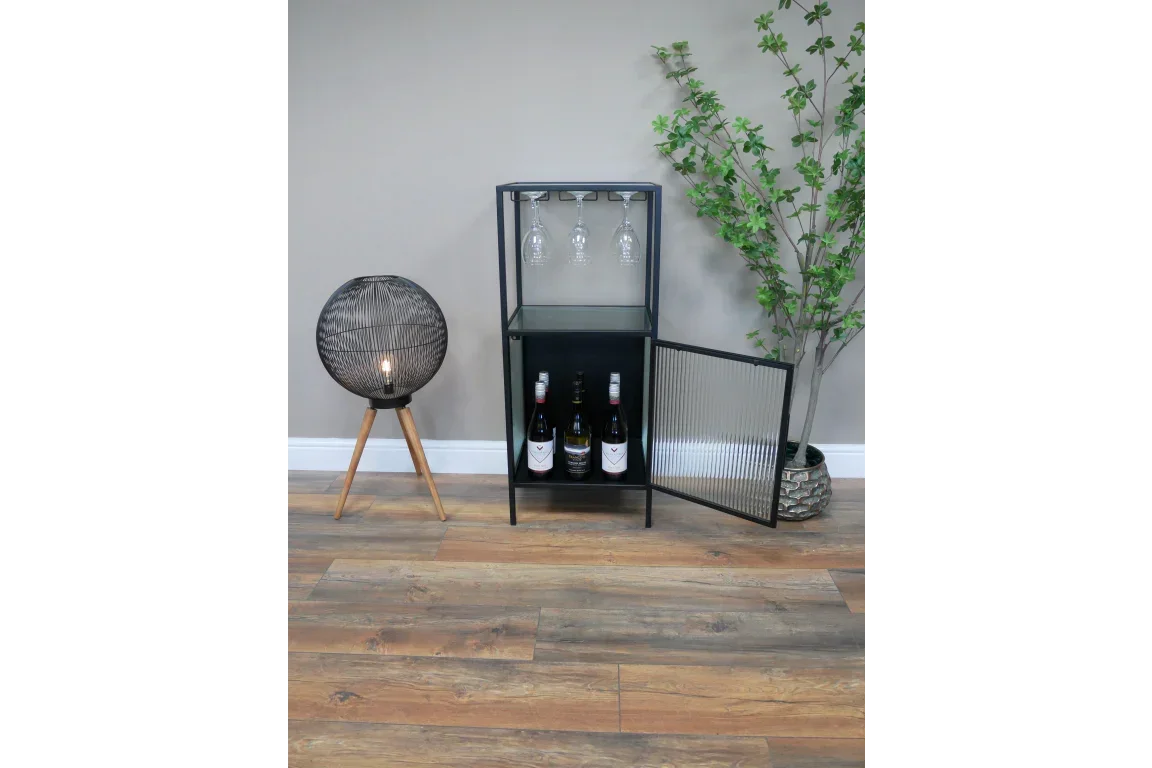 Modern black glass cabinet with wine storage and glass holders, next to floor lamp and plant