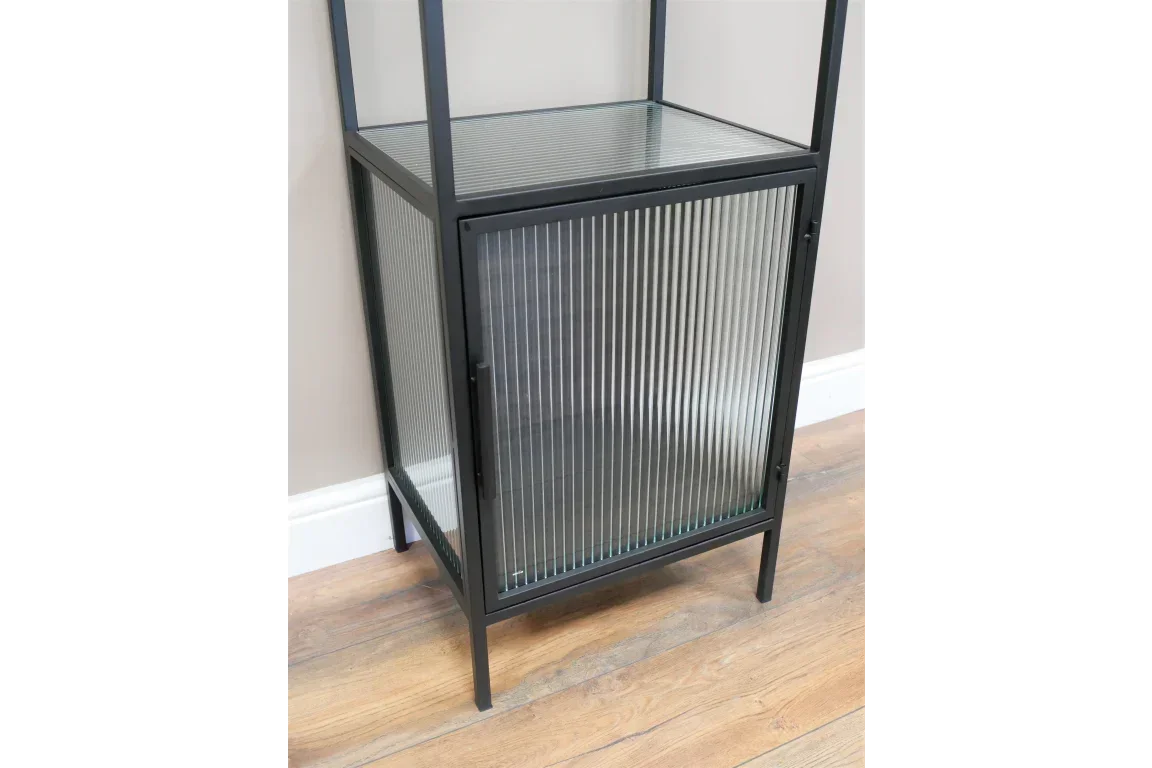 Black metal storage cabinet with ribbed glass door on wooden floor