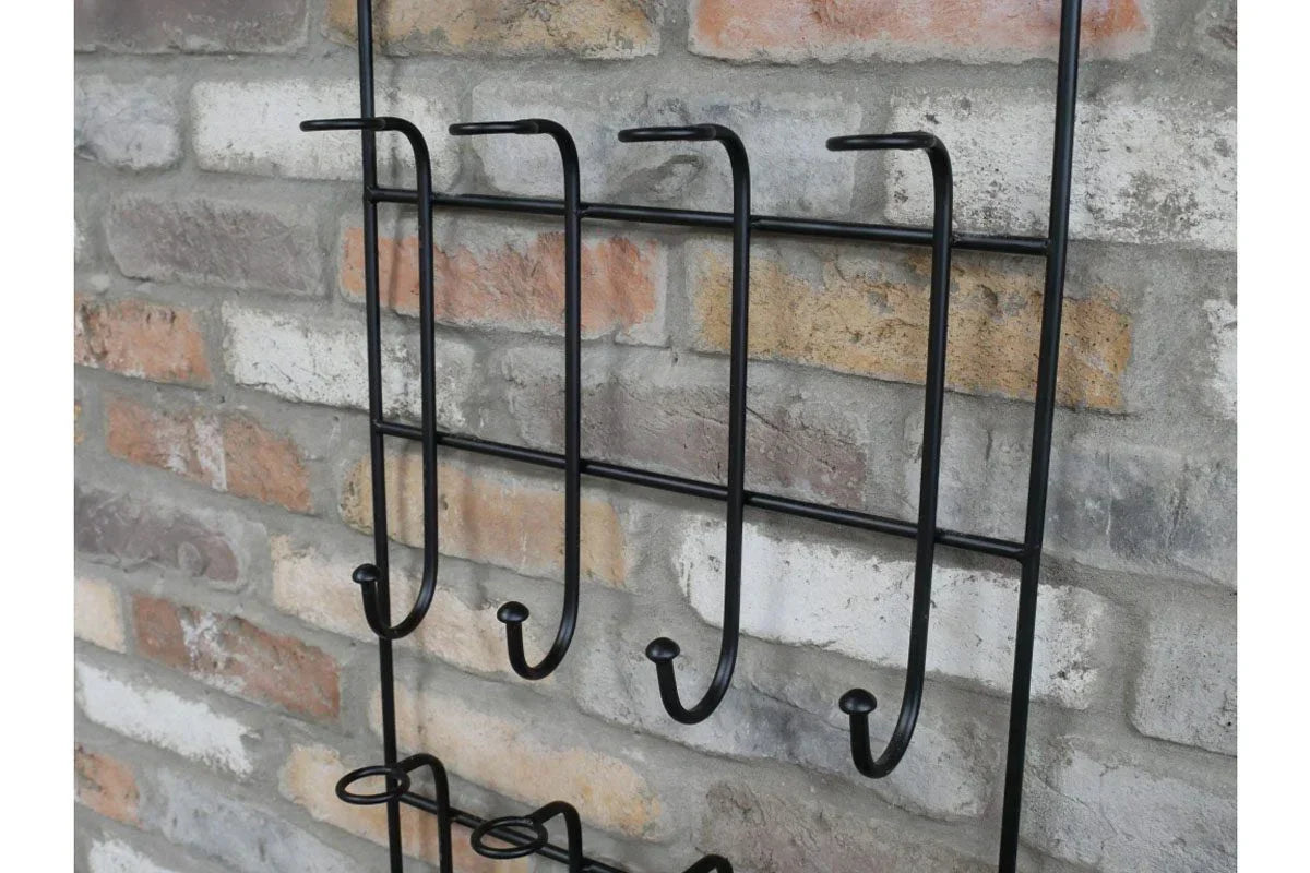Black metal wall mounted coat rack with hooks on exposed brick wall