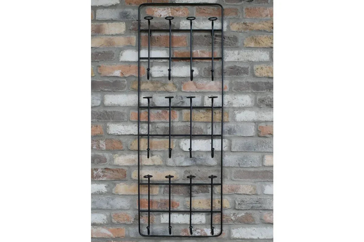 Black metal wall mounted coat rack with hooks on exposed brick background