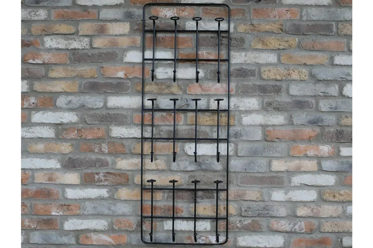 Black metal wall-mounted mug rack with twelve hooks on exposed brick wall