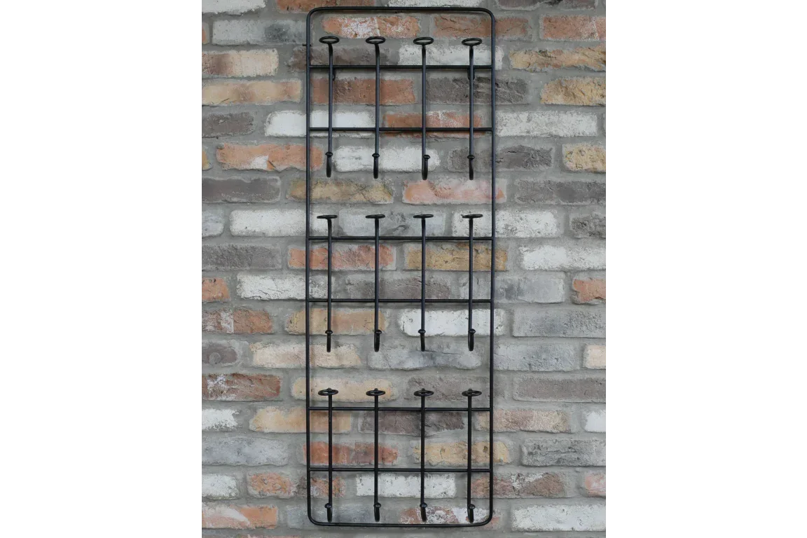 Black metal wall rack with twelve hooks mounted on exposed brick wall