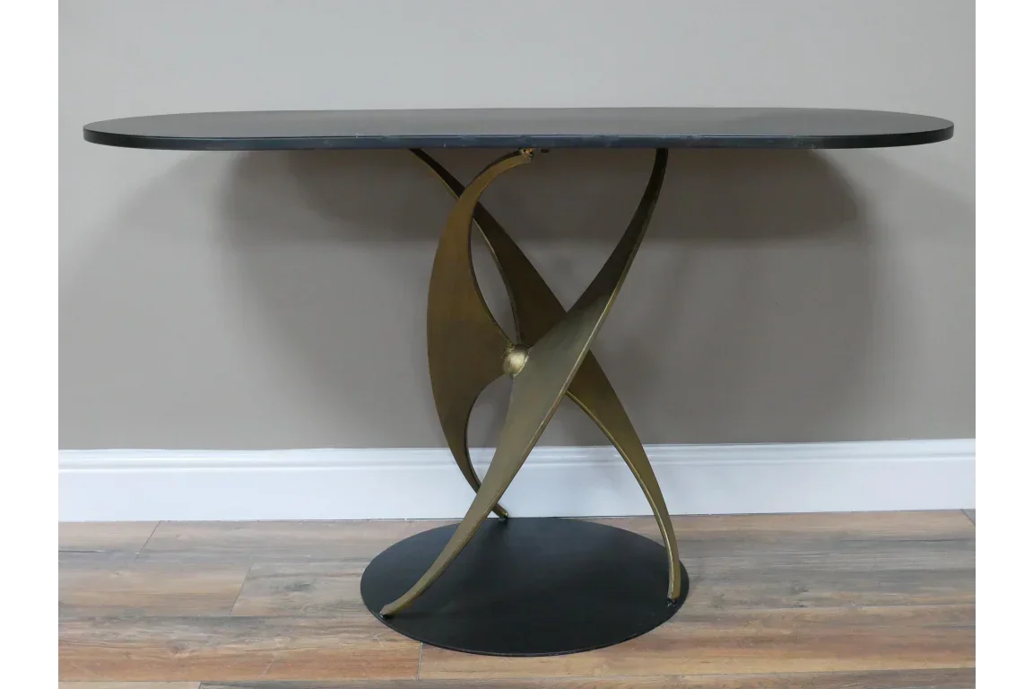 Modern console table with black oval top and sculptural gold metal base
