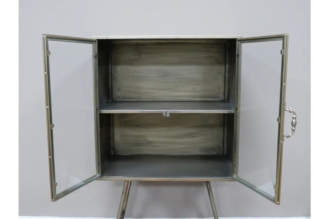 Metal display cabinet with glass doors, open shelving, and silver handles against wall