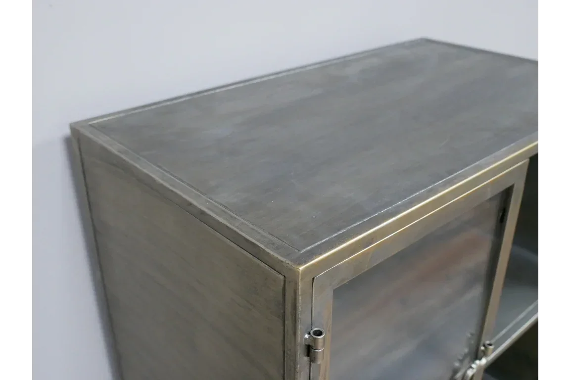 close-up of metal cabinet corner with brushed steel finish and glass door