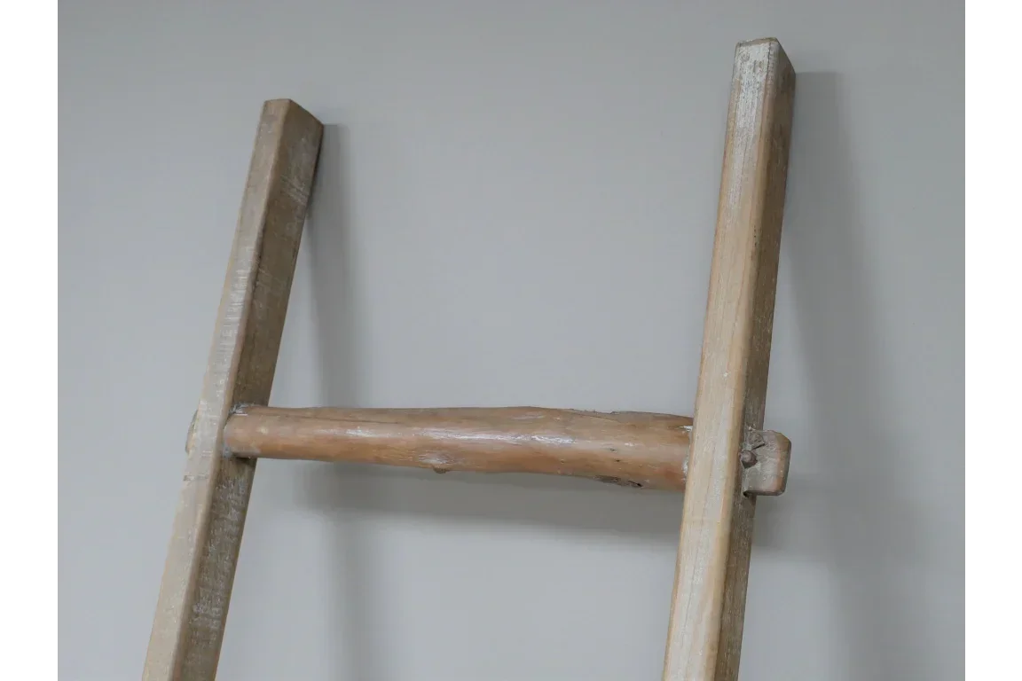 Natural wooden ladder detail with rustic finish against a neutral wall