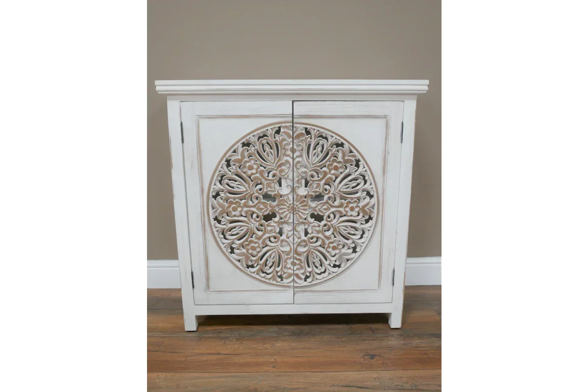 White wooden cabinet with carved floral mandala front, distressed finish, closed doors