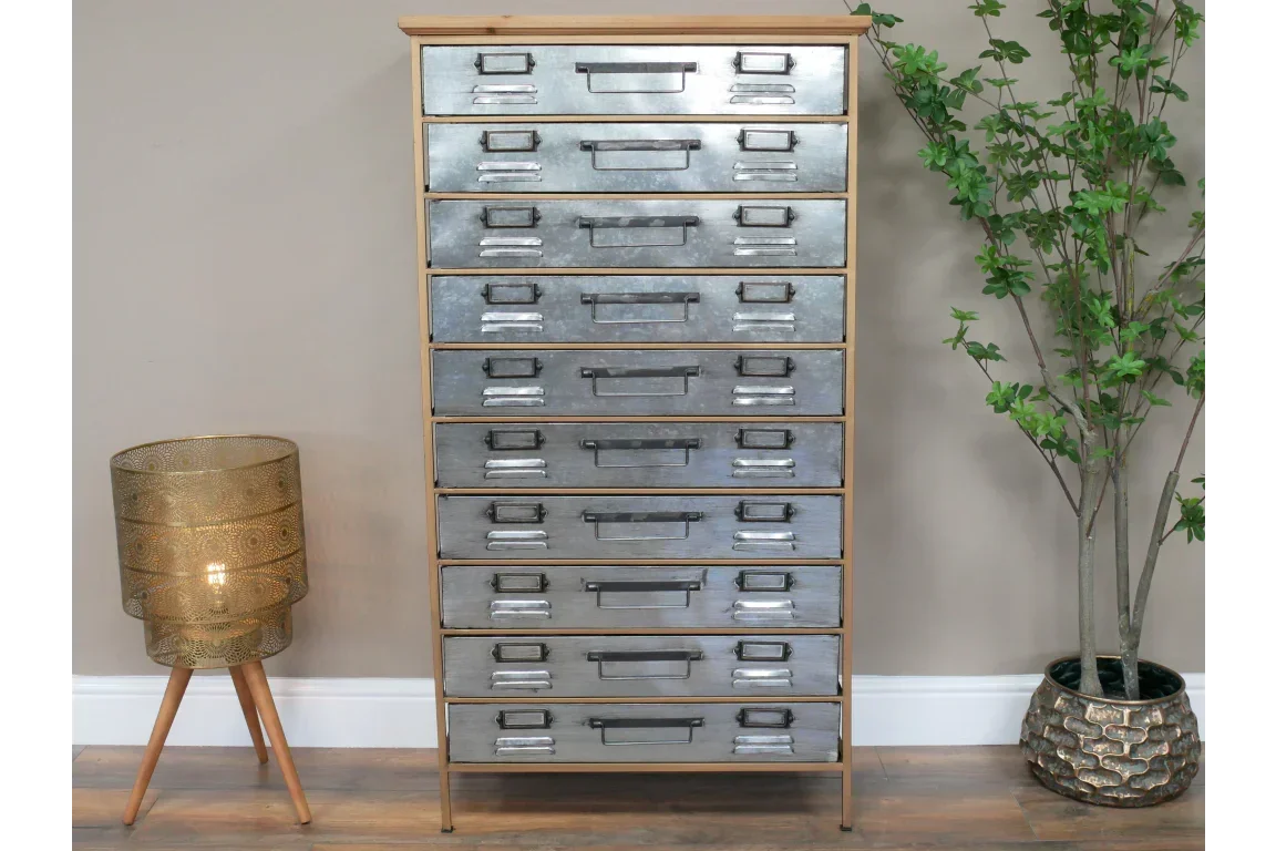 Industrial metal chest of drawers with wood frame, beside gold floor lamp and potted plant