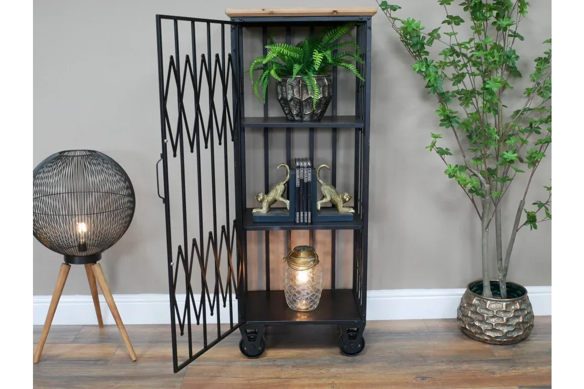 Black metal shelving unit with mesh door, wooden top, and decorative accessories