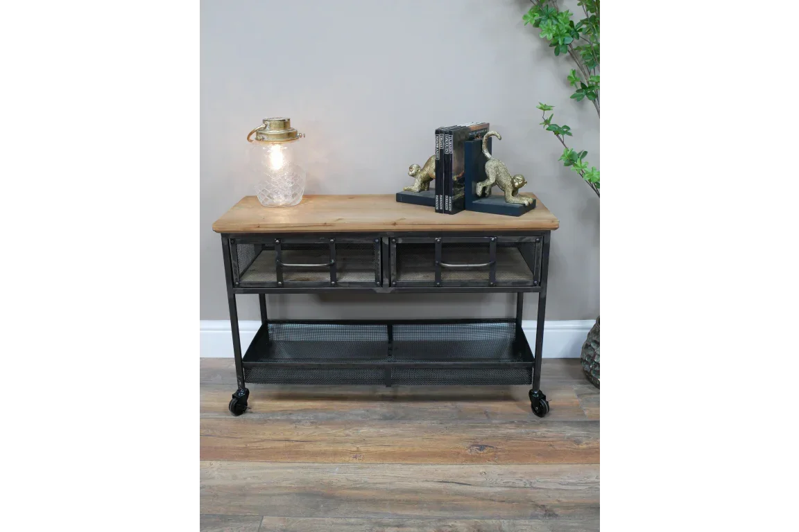 Industrial console table with metal mesh drawers, wooden top, and decorative lamp on wheels