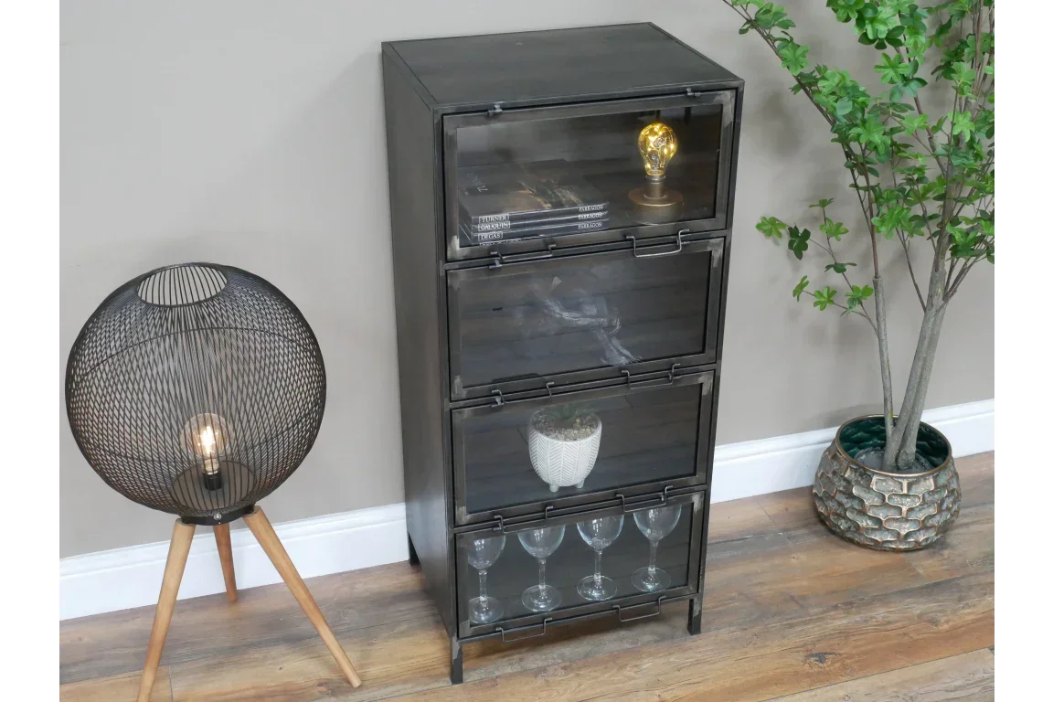 Black metal storage cabinet with glass front doors, displayed beside floor lamp and plant