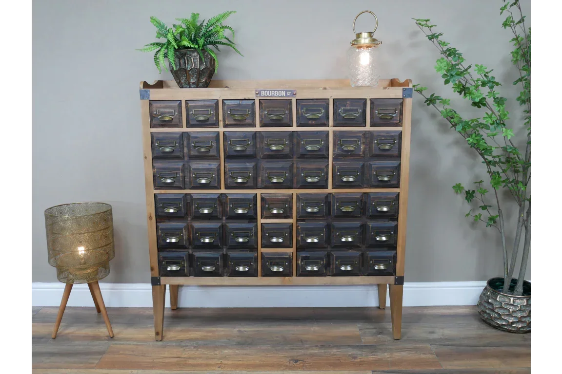 Vintage wooden storage cabinet with multiple drawers and metal handles in living room