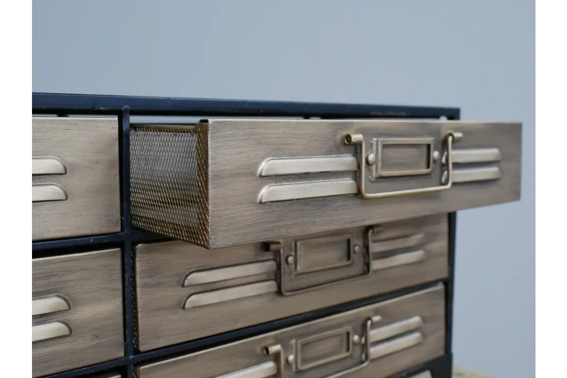 Industrial metal drawer unit with brass finish and mesh side panel, close-up view
