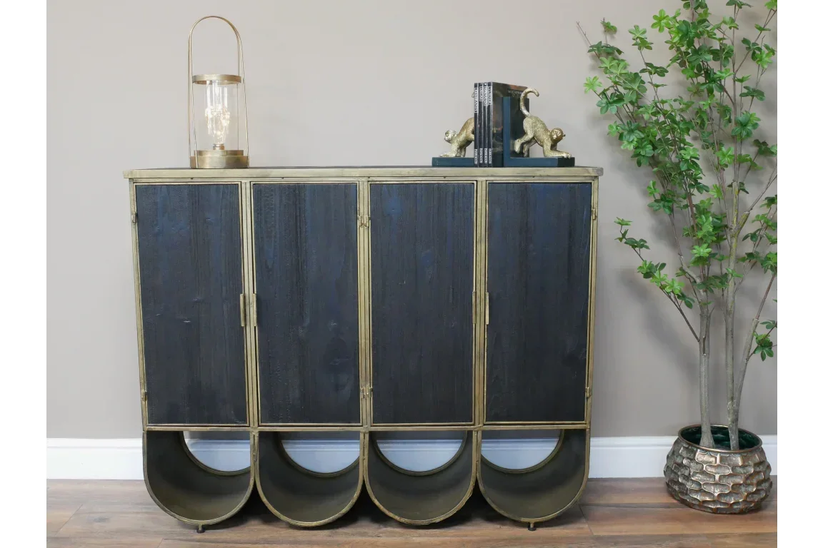 Black and gold sideboard cabinet with four doors and curved metal legs, styled in a living room