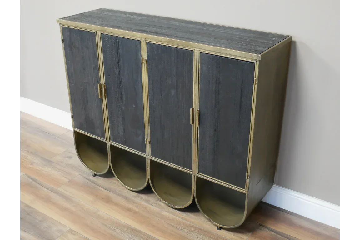 Black and gold metal storage cabinet with four doors and curved base on wood floor