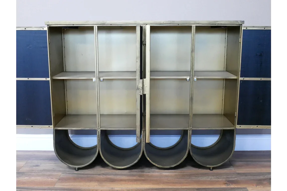 Brass metal storage cabinet with open doors and curved bases on wooden floor