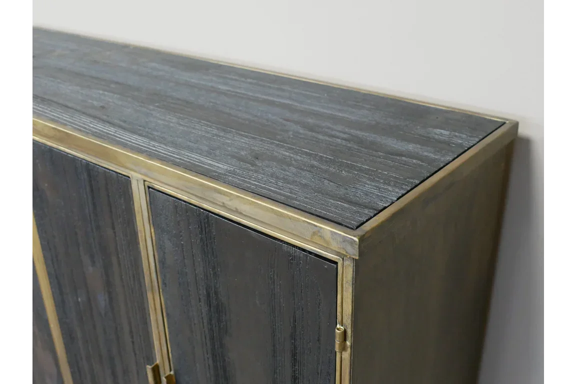 Dark wood sideboard cabinet with gold metal trim and textured surface close-up