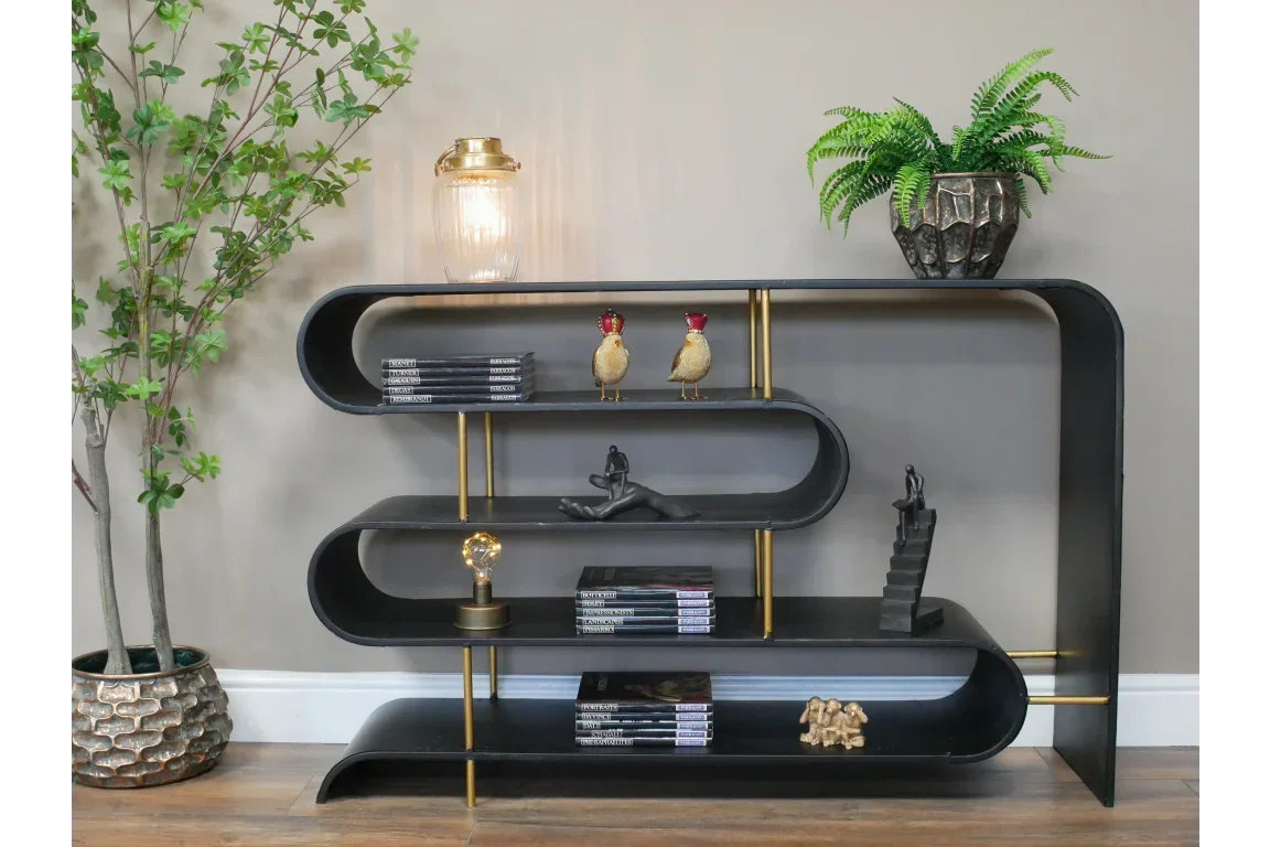 Curved black metal shelving unit with gold supports, styled with decor, books, and plants