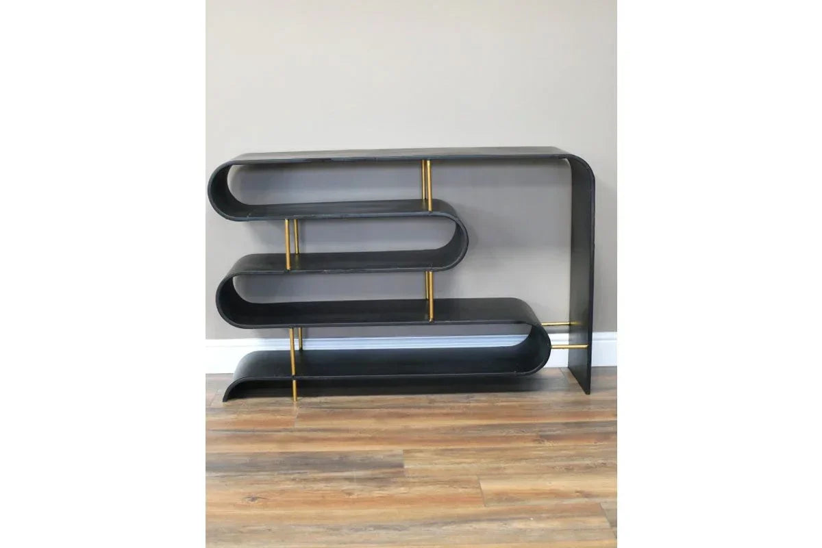 Black metal shelving unit with gold supports and curved open shelves on wood flooring