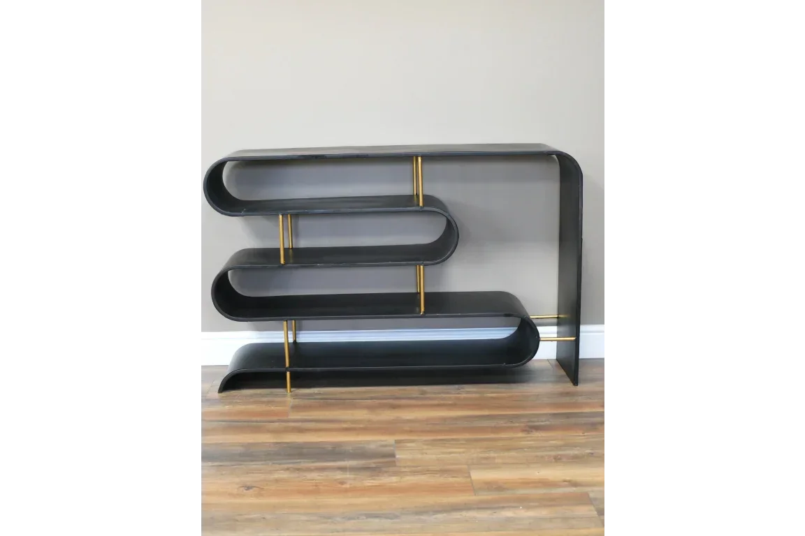 Black metal console table with curved shelves and gold supports on wood floor