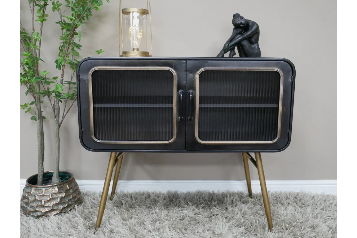 Black metal sideboard with gold legs and ribbed glass doors on grey rug