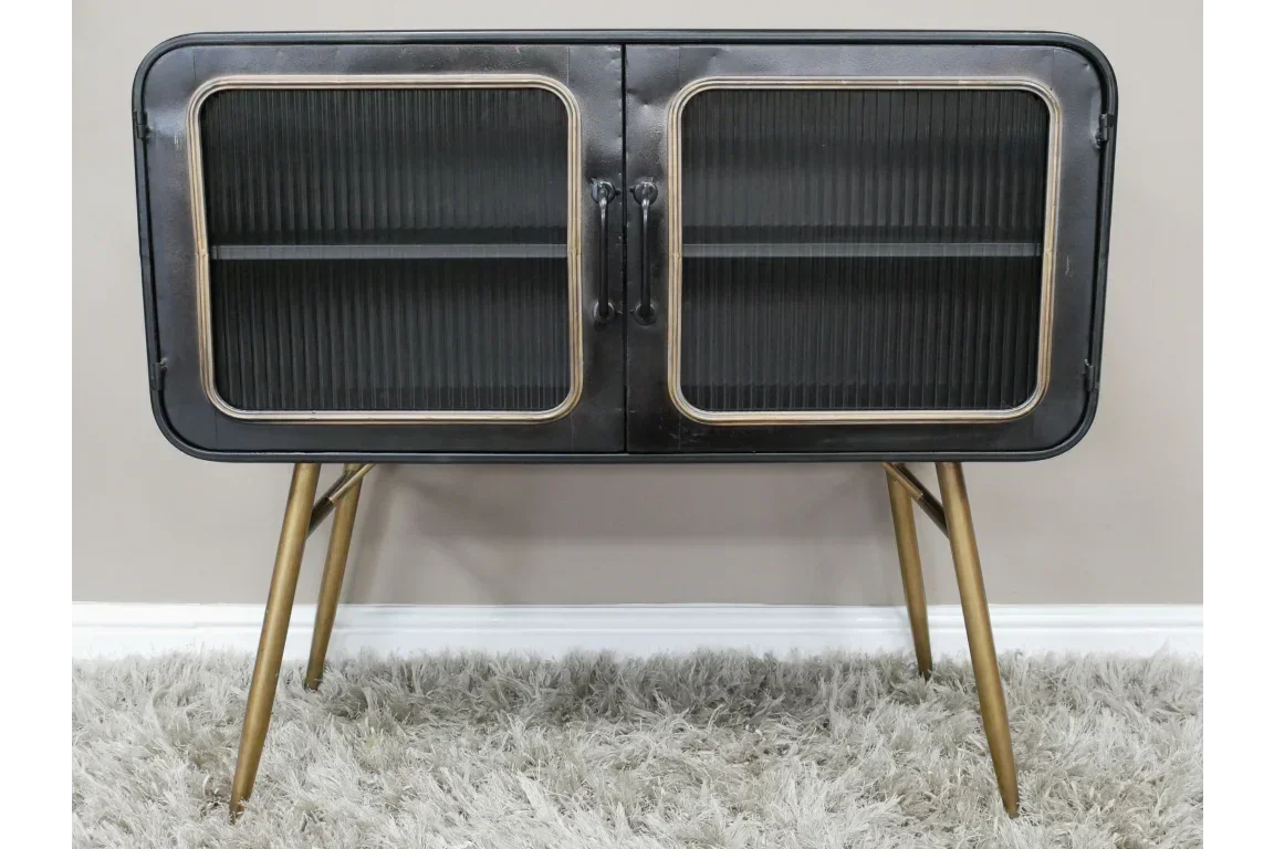 Black metal sideboard with glass doors and gold angled legs on grey rug