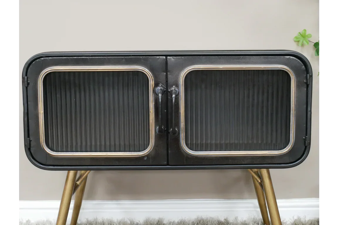 Black metal sideboard with glass doors and gold legs on carpet