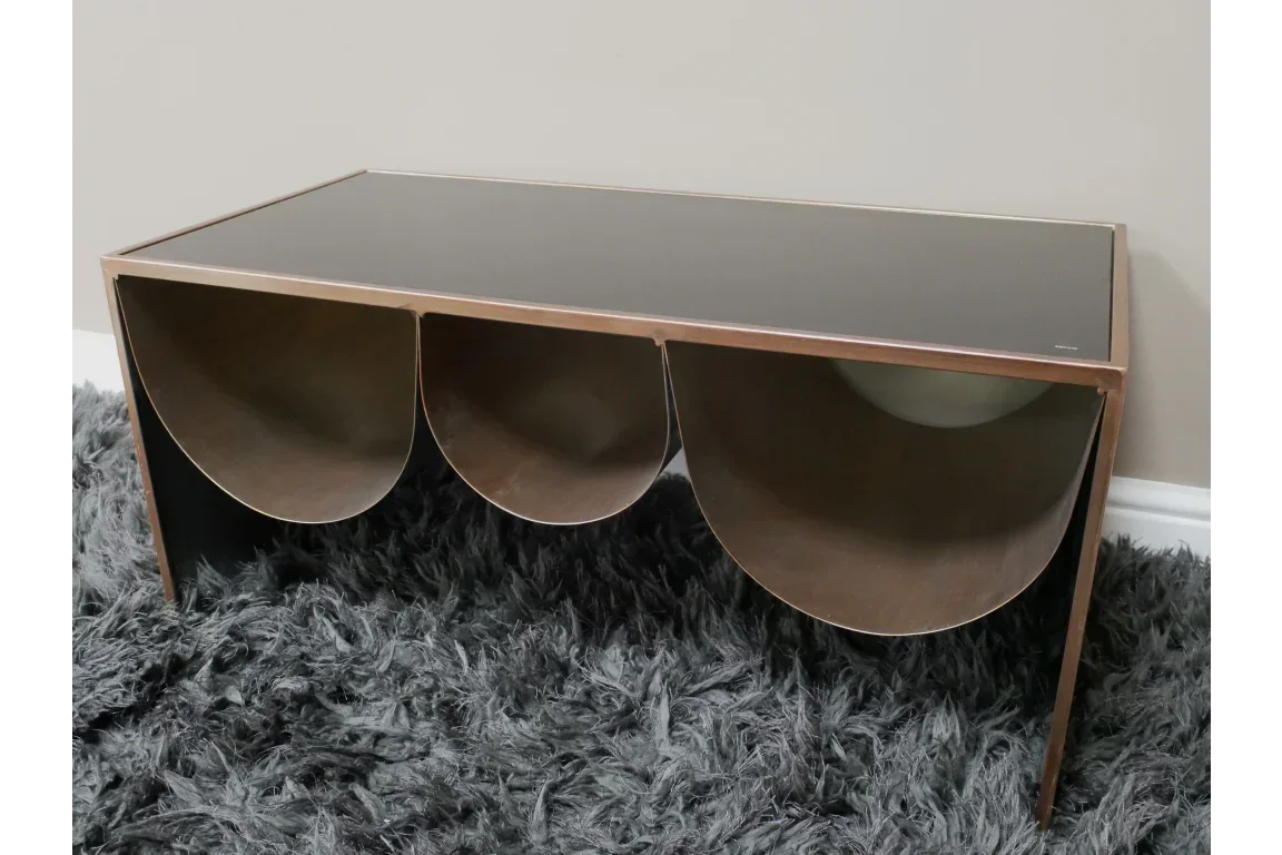 Modern coffee table with bronze frame, black glass top and curved storage compartments