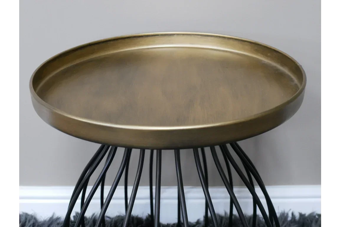 Round brass side table with black metal legs and raised edge, shown from a front angle