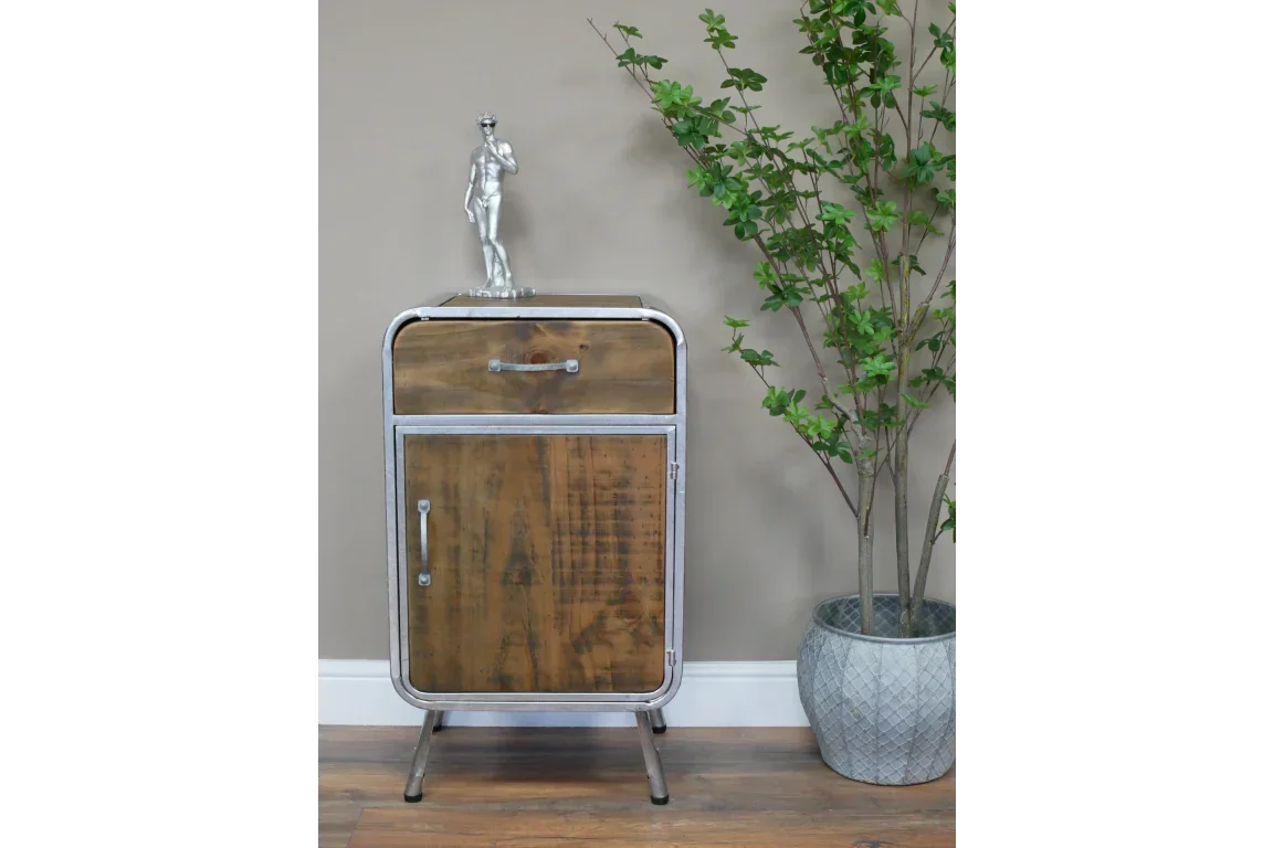 Industrial style wooden cabinet with metal frame beside potted plant and silver sculpture