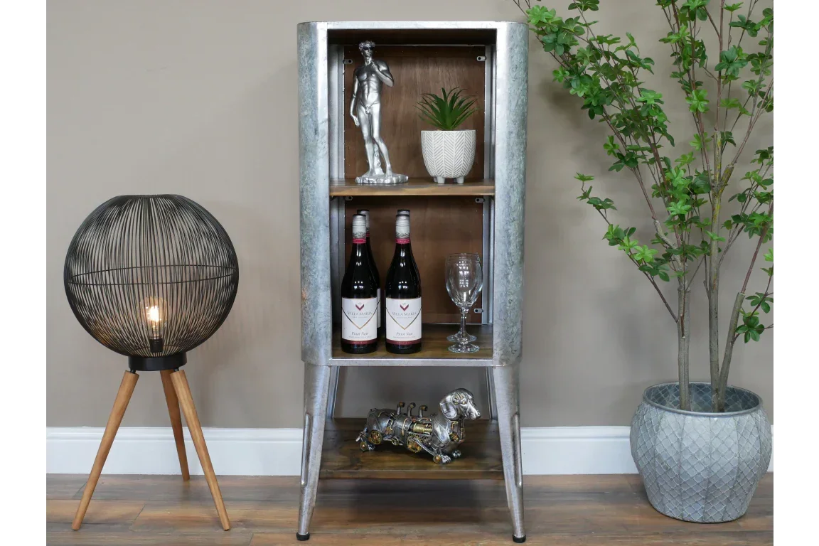 Industrial metal display cabinet with shelves beside tripod floor lamp and potted plant
