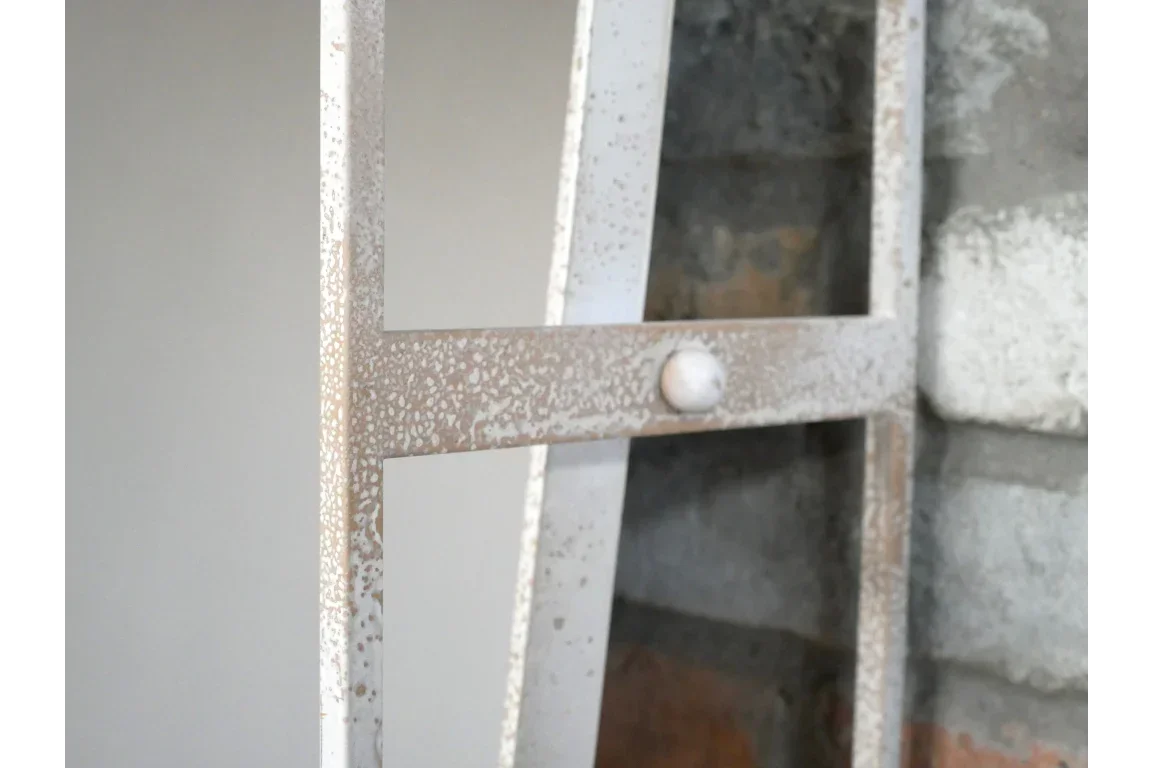 Close-up of distressed metal frame detail on rustic industrial shelving unit