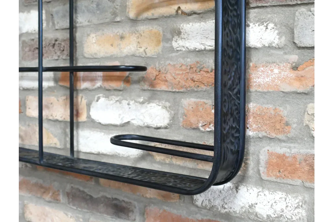 Black metal wall shelf with curved edge mounted on exposed brick wall