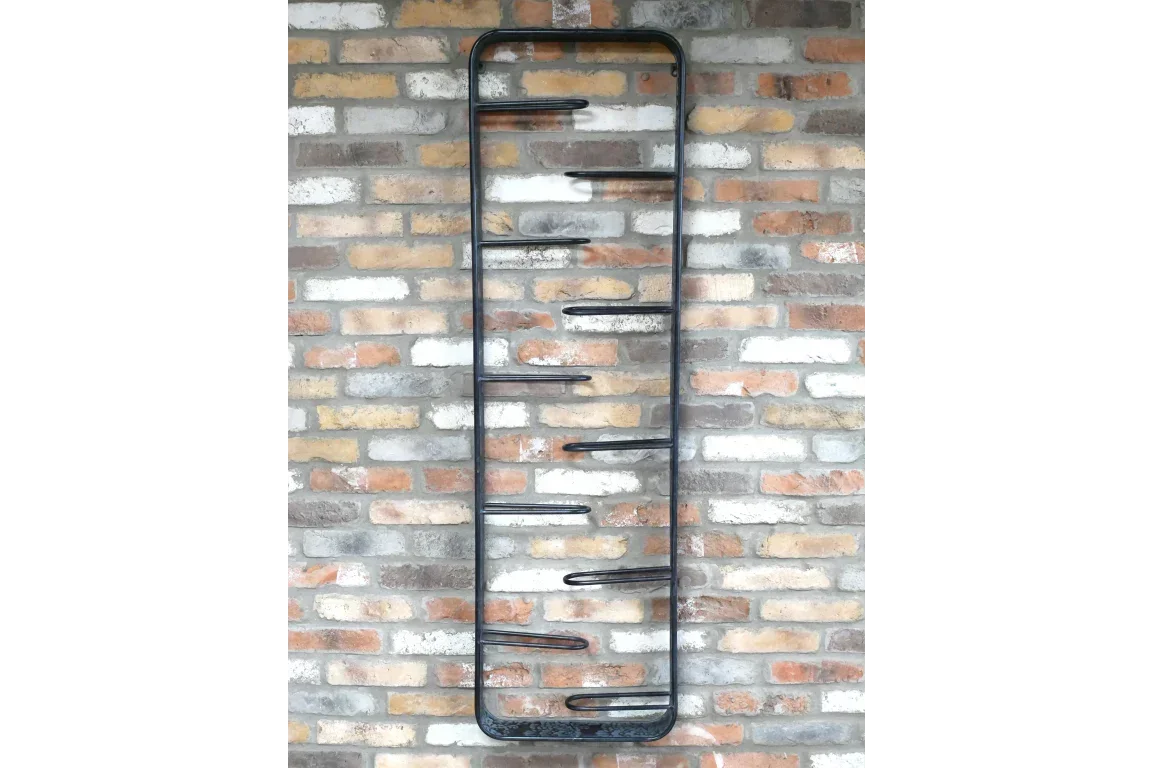 Black metal wall-mounted wine rack with eight holders on exposed brick wall