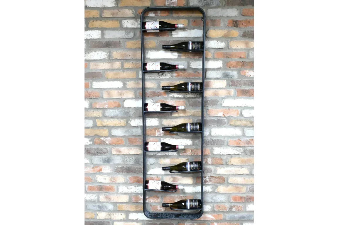 Wall-mounted metal wine rack with eight bottles against exposed brick wall
