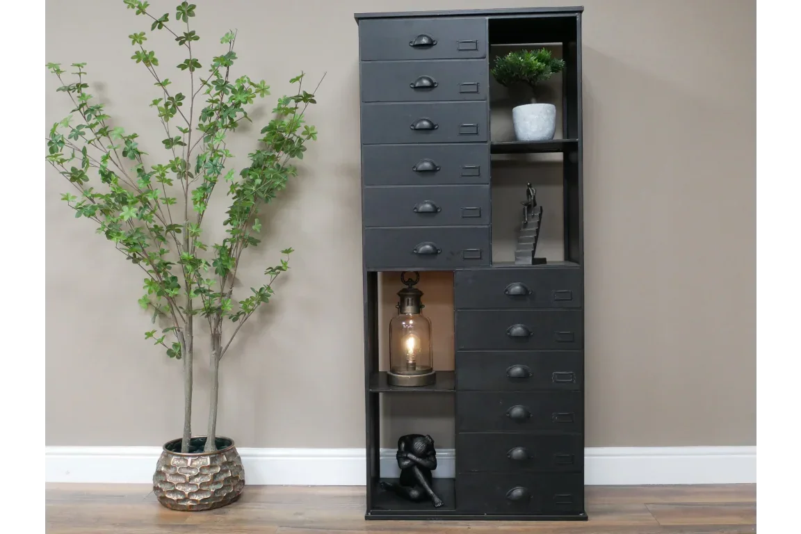 Black metal tall chest of drawers with open shelving, lamp, and decor accents