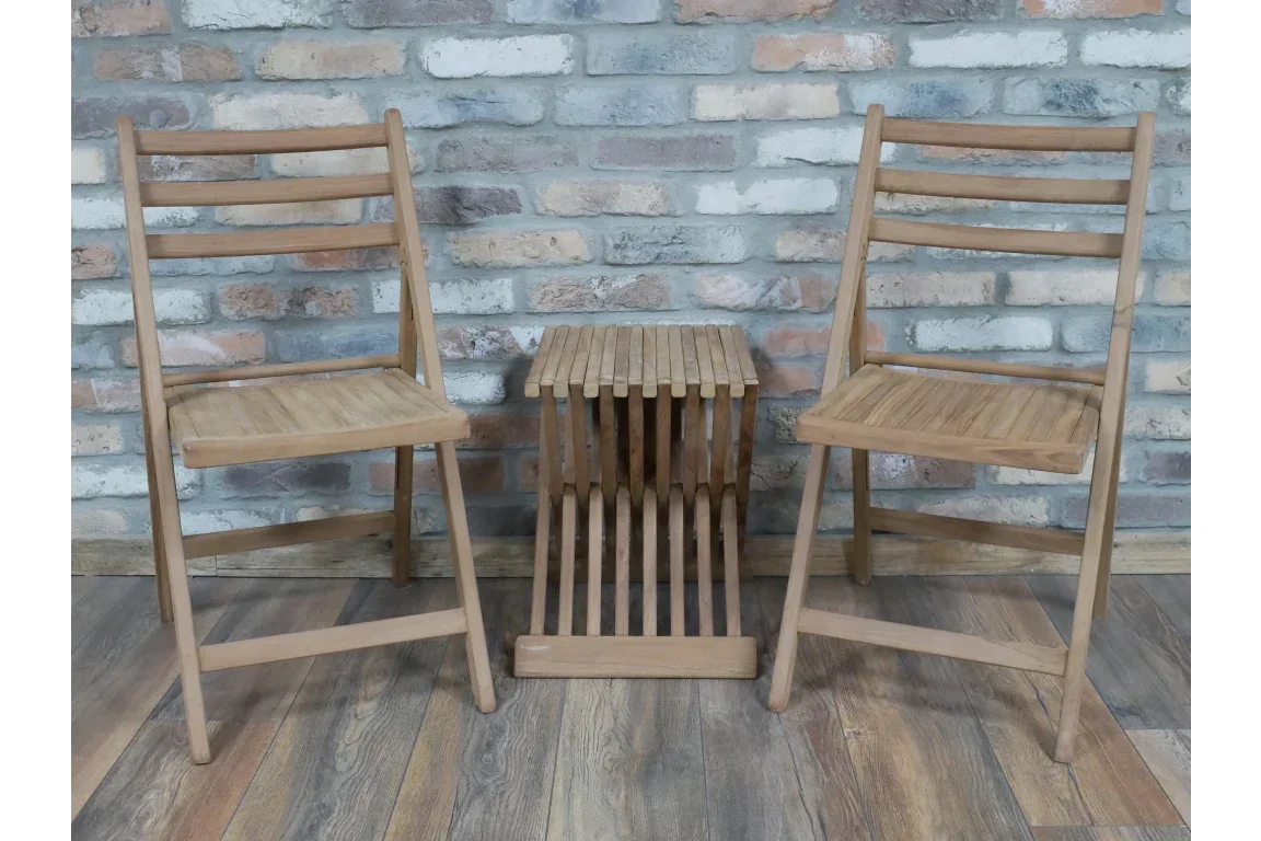 Wooden dining chairs with matching slatted side table against brick wall on wooden floor