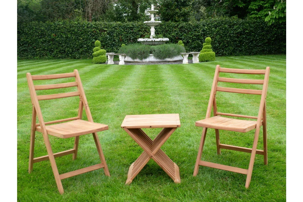 Wooden folding garden chair set with small table on grass, landscaped garden background