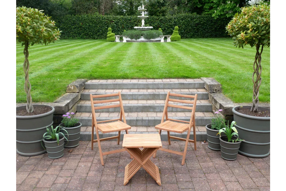 Wooden garden bistro set with two chairs and side table on patio, surrounded by planters