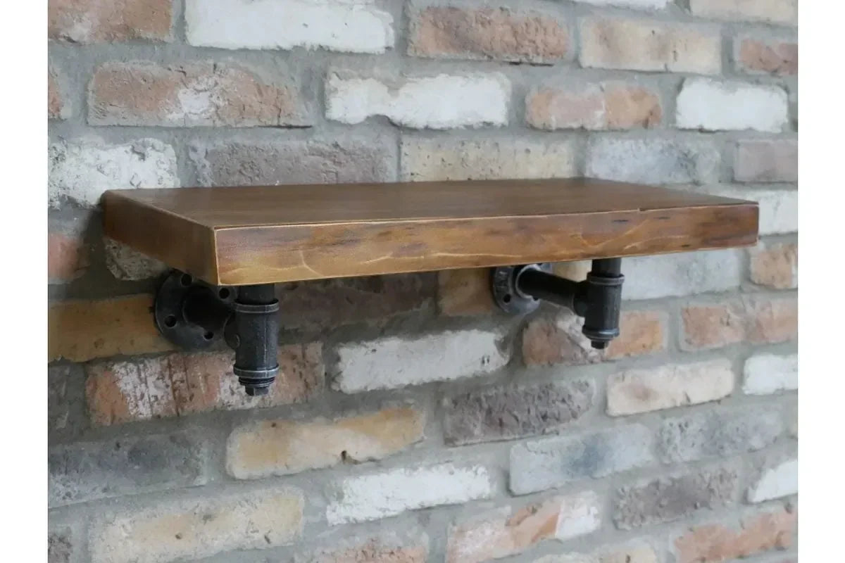 Industrial pipe wall shelf with wooden top on exposed brick wall