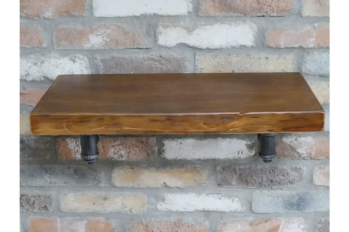 Rustic wooden shelf with dark metal pipe brackets mounted on a brick wall